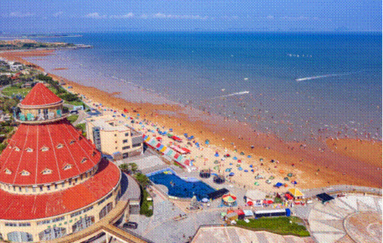 游客在青岛蓝谷海滩亲海游憩